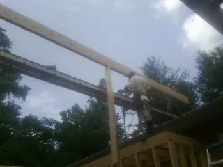 Carpenter setting a ridge beam over a new addition frame — Ice Dam Removal by Roofing Brothers in Ashuelot