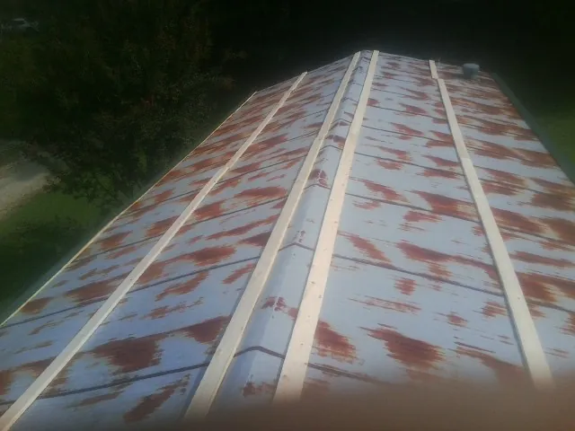 Rusted metal roof panels with new wood purlins before replacement — Storm Damage Roof Repair in Ashuelot by Roofing Brothers