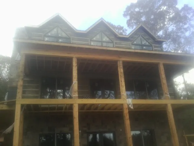 Dormers and porch framing on a large log home under construction — Roof Coating work by our crew in Ashuelot