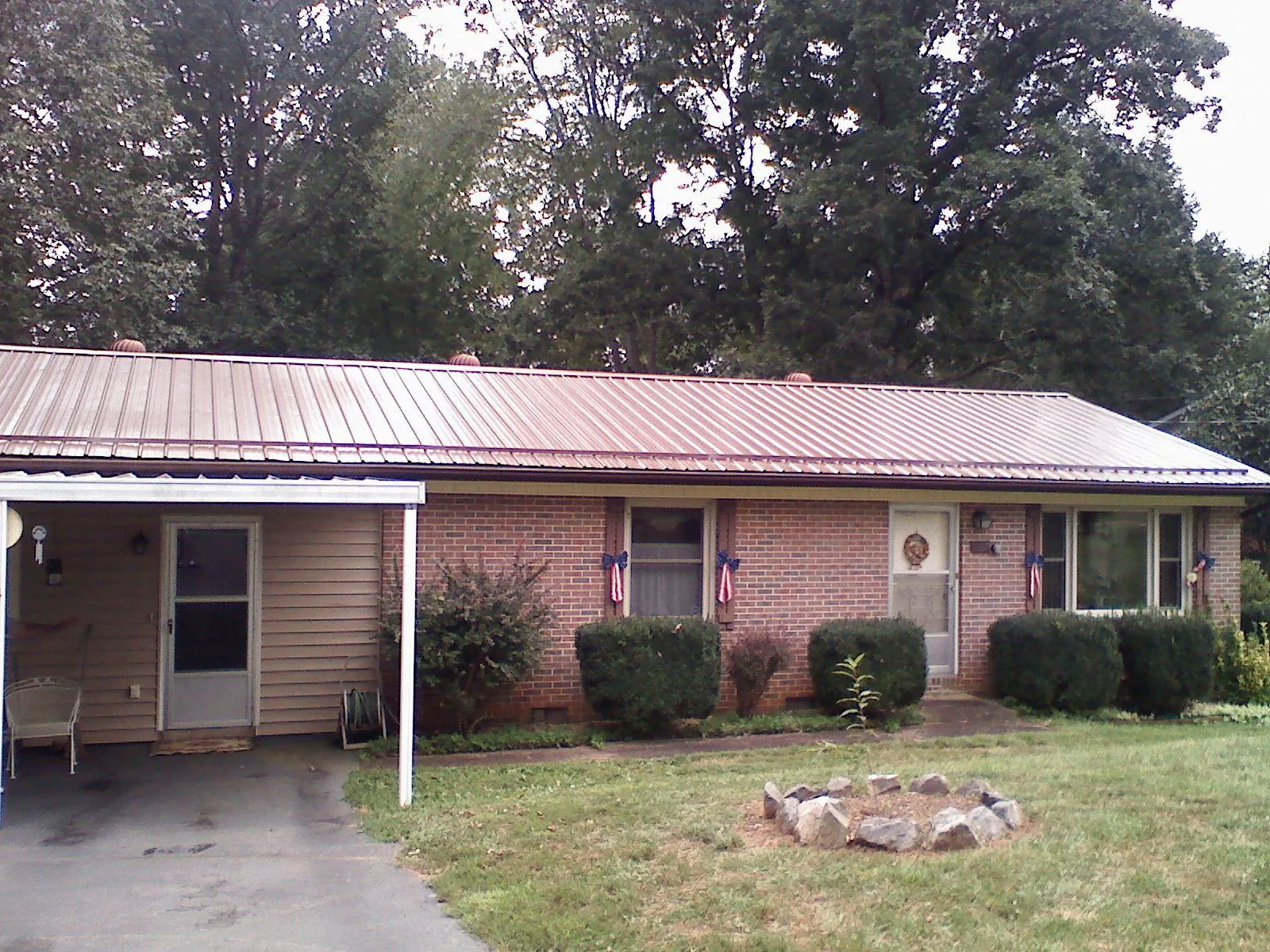 Bronze metal roof and carport on a brick ranch home — Roof Repair work by our crew in Ashuelot
